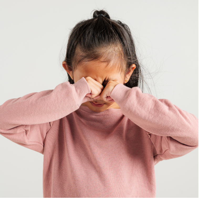 Child wearing a pink long-sleeve shirt against a white background