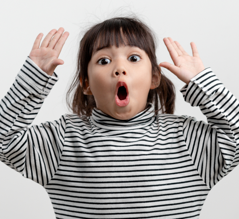 Child wearing a black and white striped shirt with hands raised on a light gray background
