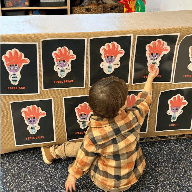 Child interacting with educational posters on a classroom wall