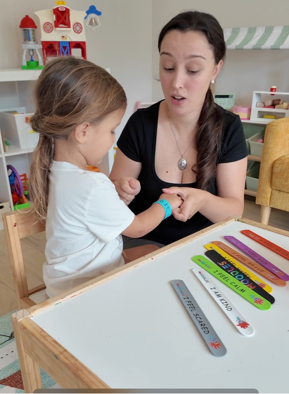 Woman and child interacting at a table with educational tools in a classroom setting